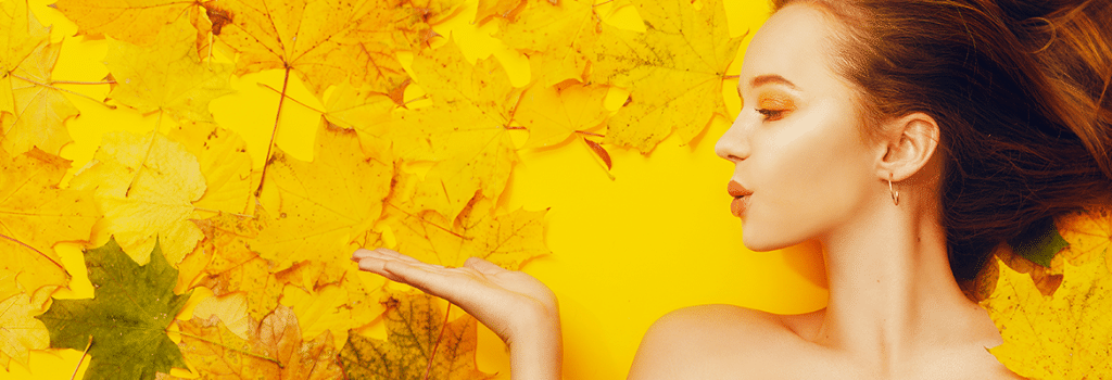 woman with leaves spread behind her, bright yellow background